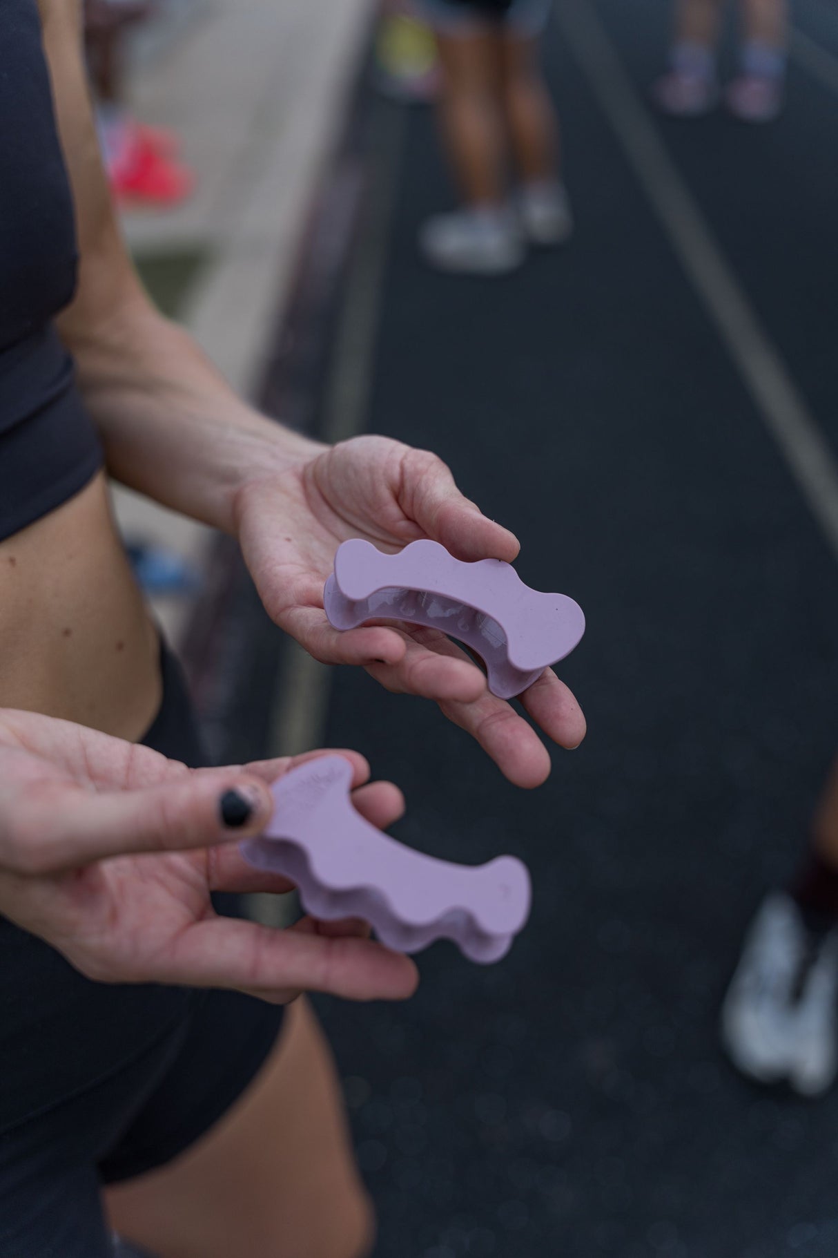 Pair of mauve silicone toe spacers designed with rounded edges for athletic use.