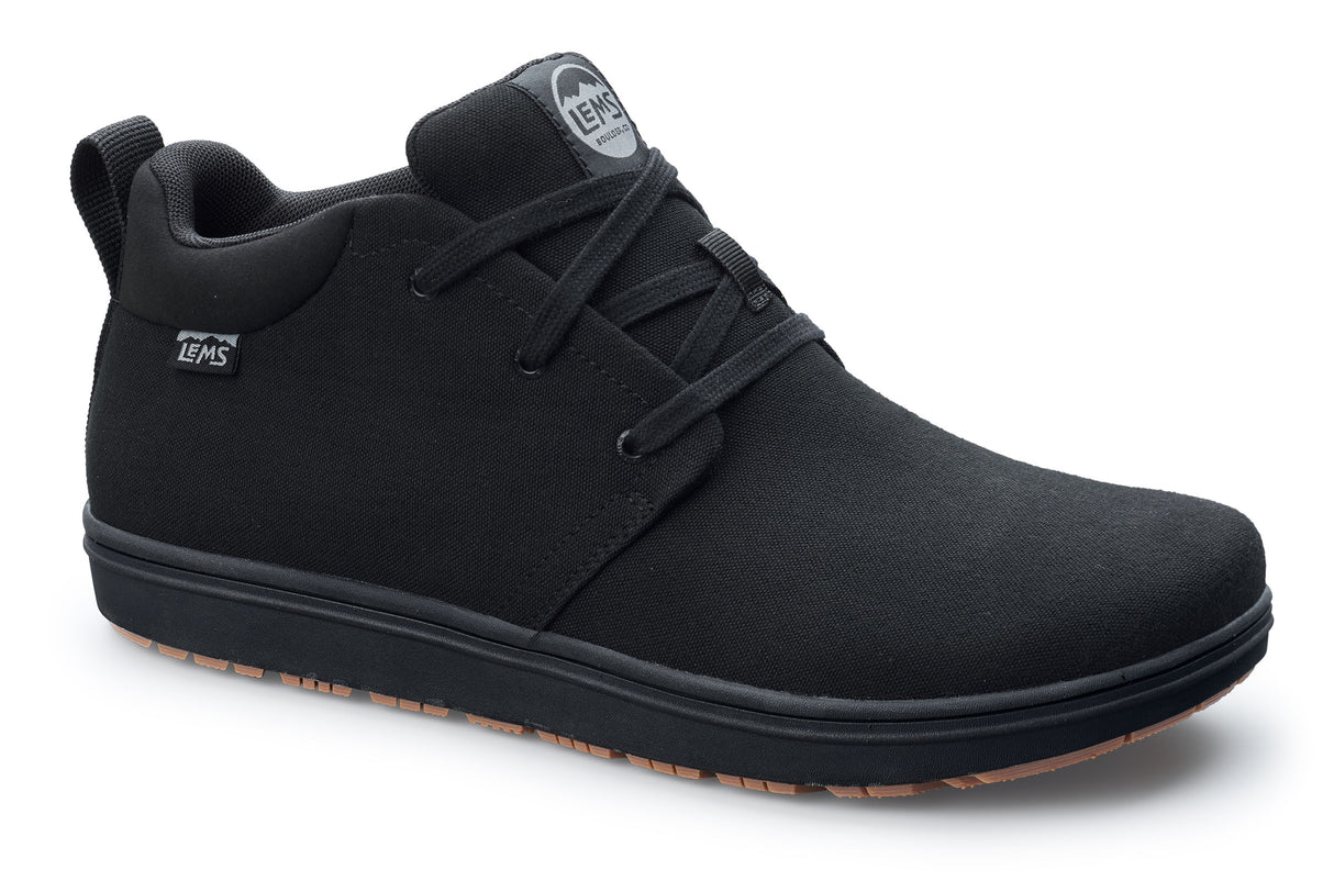 Black canvas casual chukka shoe with black laces and textured brown sole.