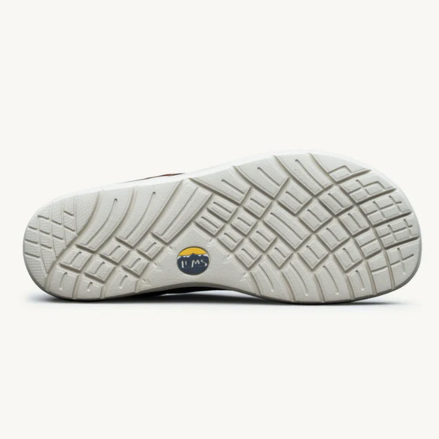 Cream-colored shoe sole with deep tread pattern and circular Lems logo in center.