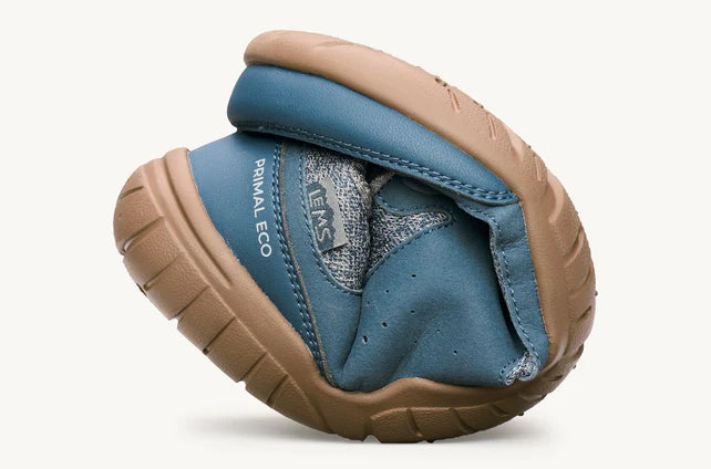 Blue and tan flexible Lems Primal Eco shoe folded to show softness and sole design.