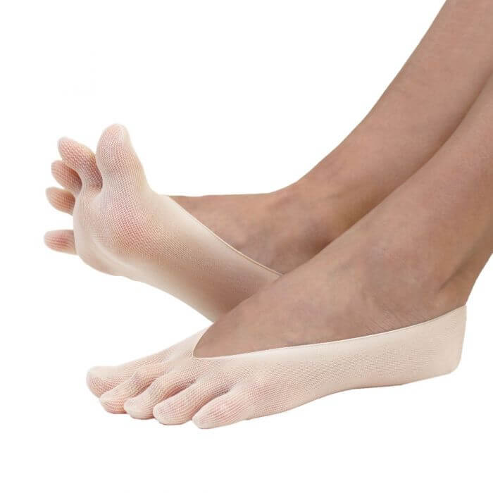 Beige nylon no-show toe socks covering toes and heel with open midfoot design on feet.