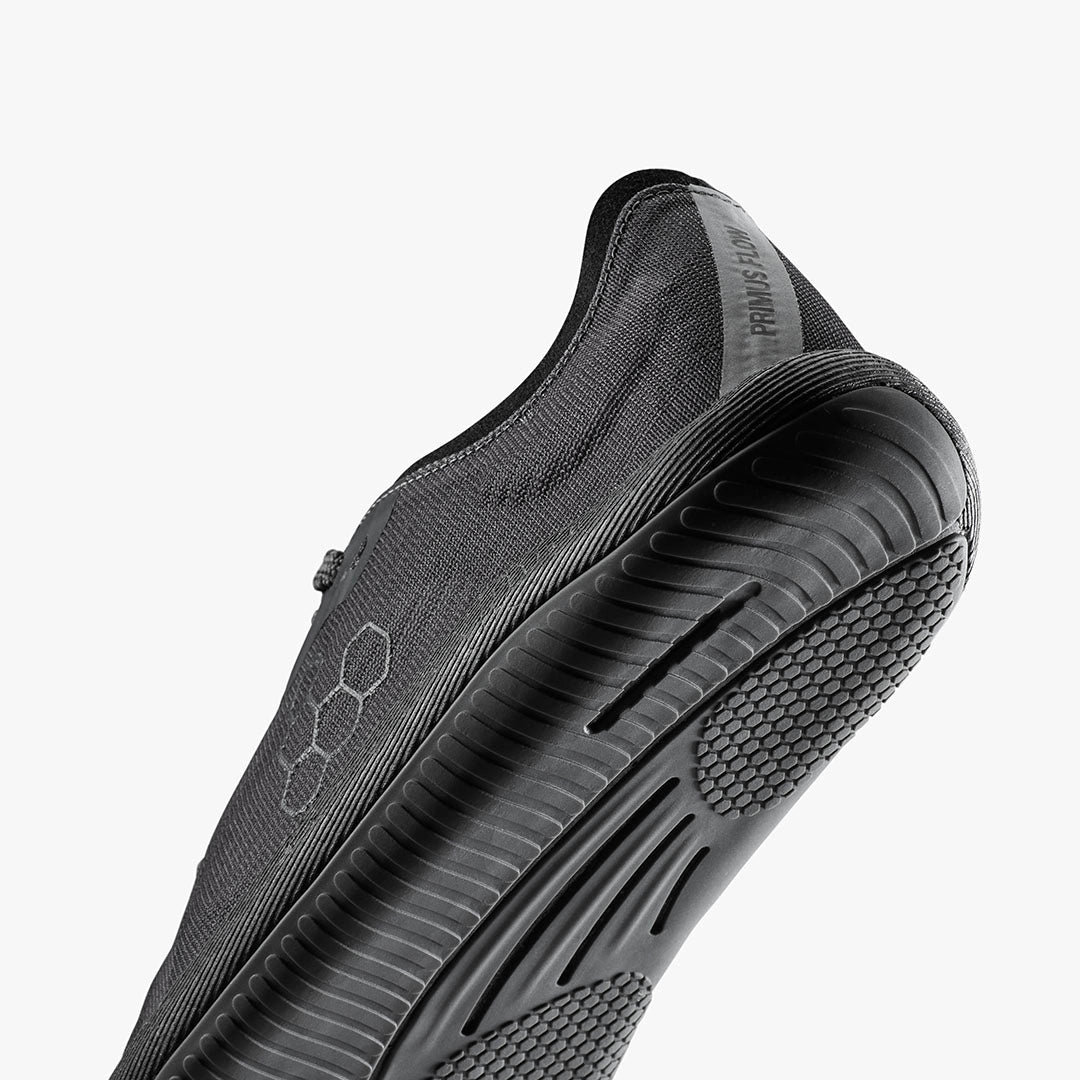 Dark shadow Vivobarefoot men's athletic shoe with textured sole and hexagonal pattern on side.
