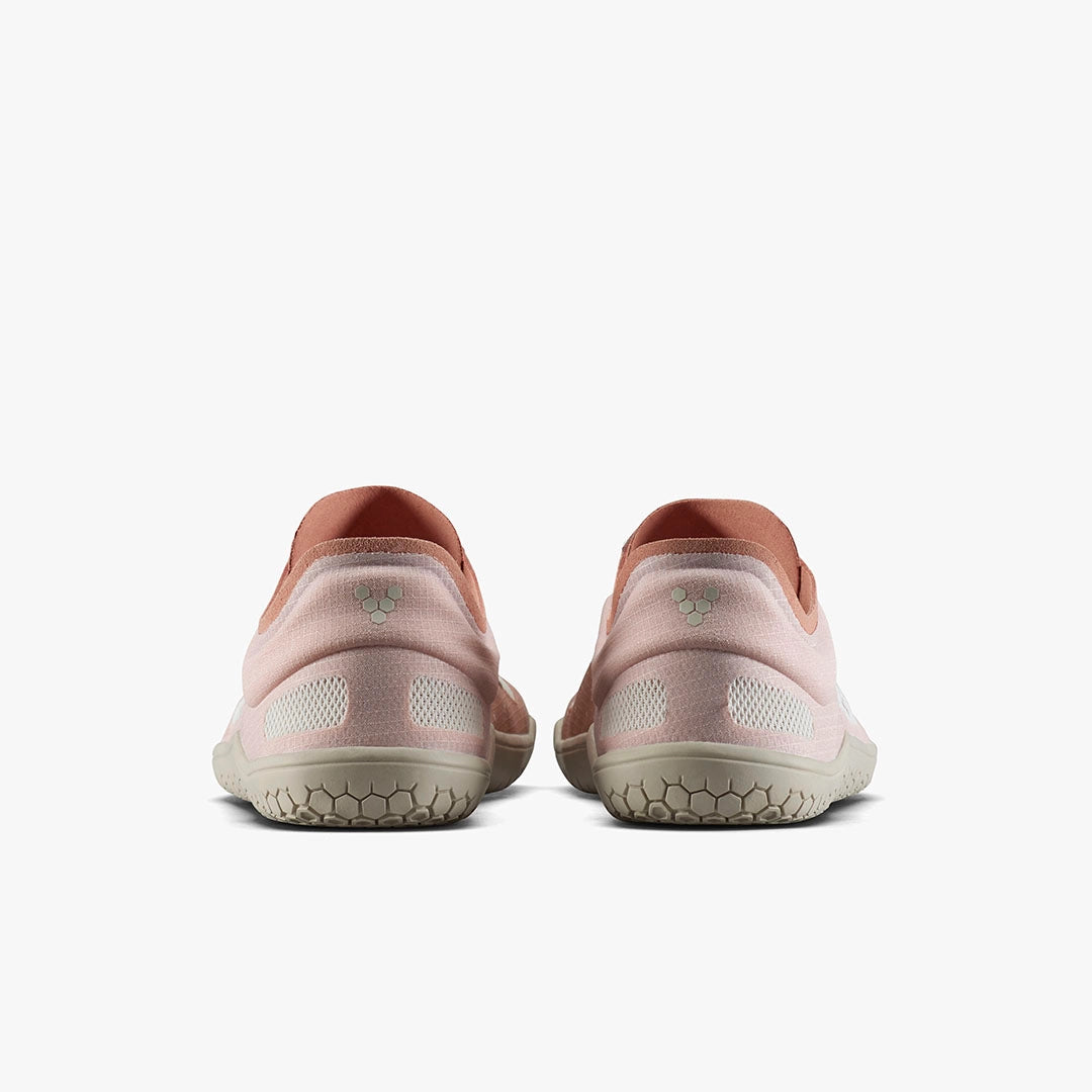 Pair of dusty rose athletic shoes with textured beige soles, viewed from the back.