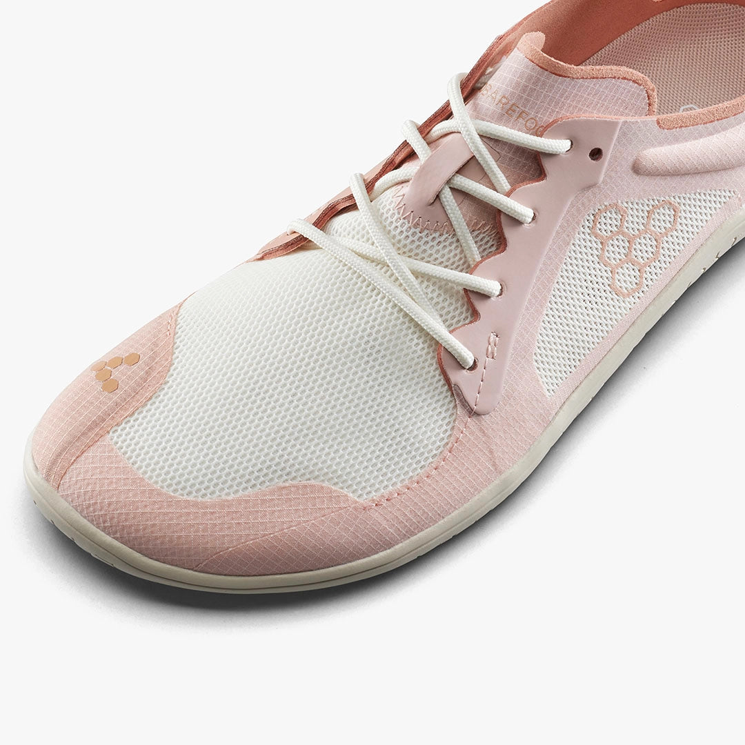 Light pink and white breathable mesh athletic shoe with minimalist sole and elastic laces.