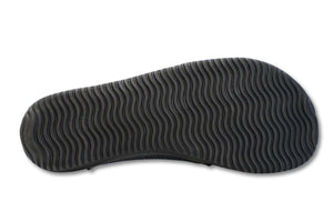 Black sneaker sole with wavy tread pattern in vegan leather slip-on style.
