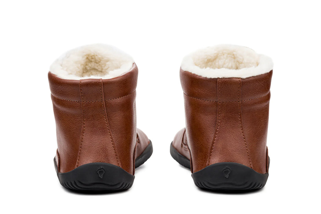 Brown leather ankle boots with plush white fleece lining and black rubber soles, rear view.