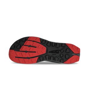 Black and red athletic shoe sole with multidirectional tread pattern and textured grip areas.