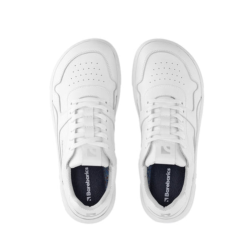 All-white leather sneakers with perforated toe box and lace-up closure.