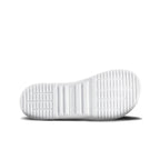 All-white leather shoe sole with textured grip pattern and rectangular grooves.