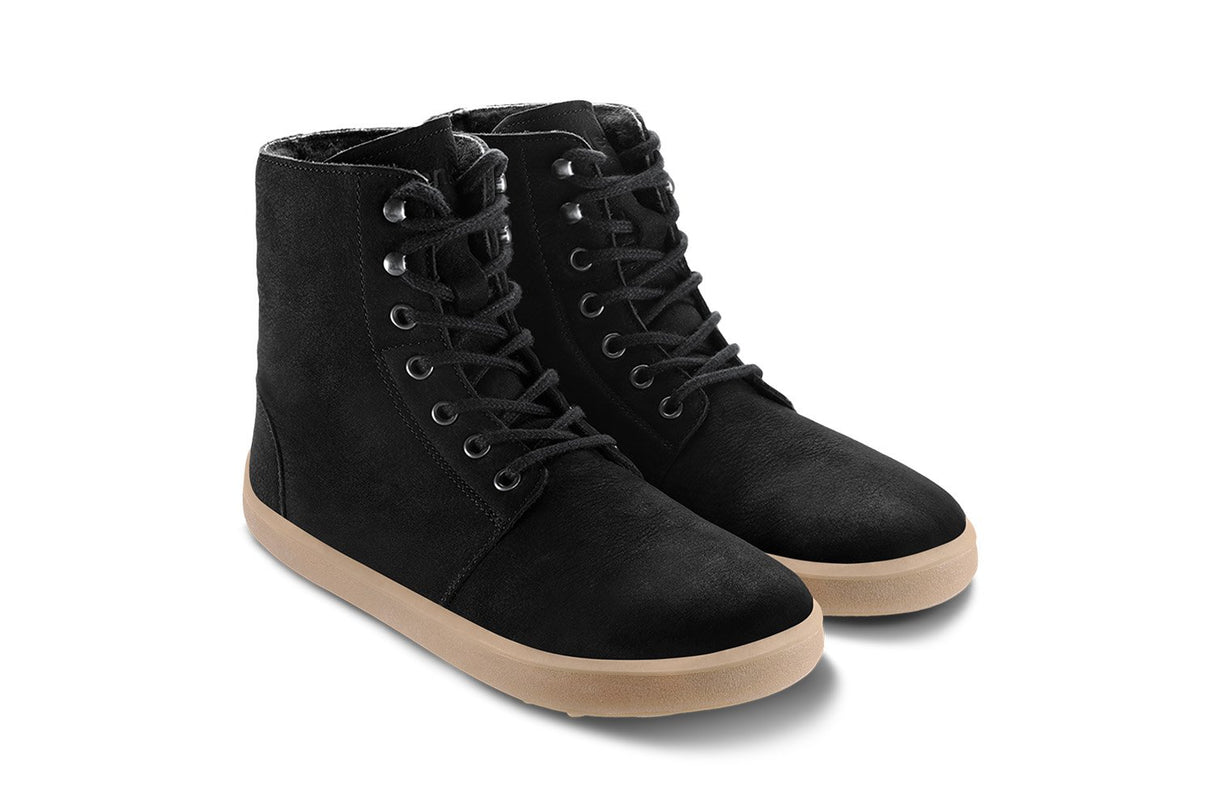 Matt black winter boots with tan rubber sole, lace-up front, and high ankle design.