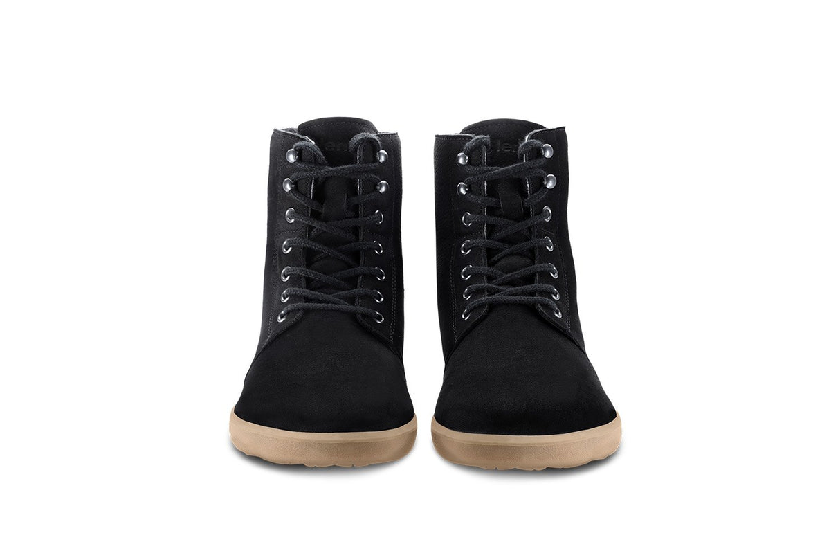 Matt black winter boots with lace-up front and light brown rubber soles, front view.