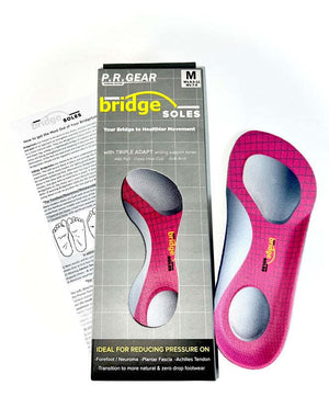 Medium-sized pink 3/4 length insoles with gray metatarsal pads and yellow branding alongside packaging and instruction sheet.