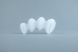 Clear flexible silicone toe spacer with five individual loops for each toe on light gray background.