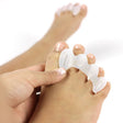 White silicone toe spacer on a foot, separating and aligning toes for comfort and correction.