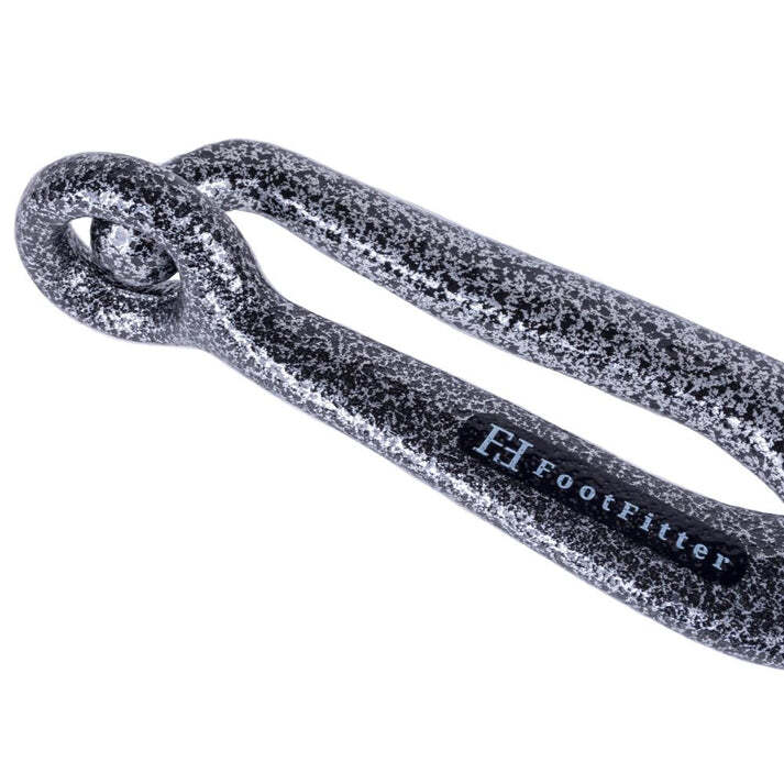 Speckled black cast iron FootFitter bunion stretcher with looped end and rectangular slot.