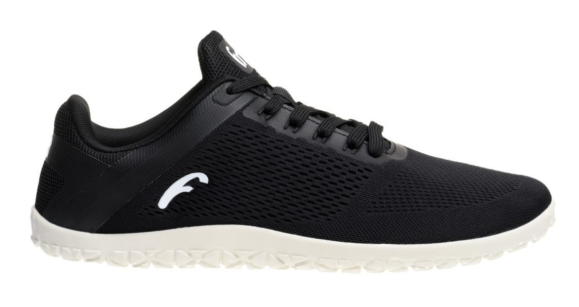 Black low-top sneaker with breathable mesh upper, white textured sole, and minimalist logo on side.