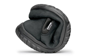 Black waterproof Chelsea boot folded to show flexibility and soft sole texture.