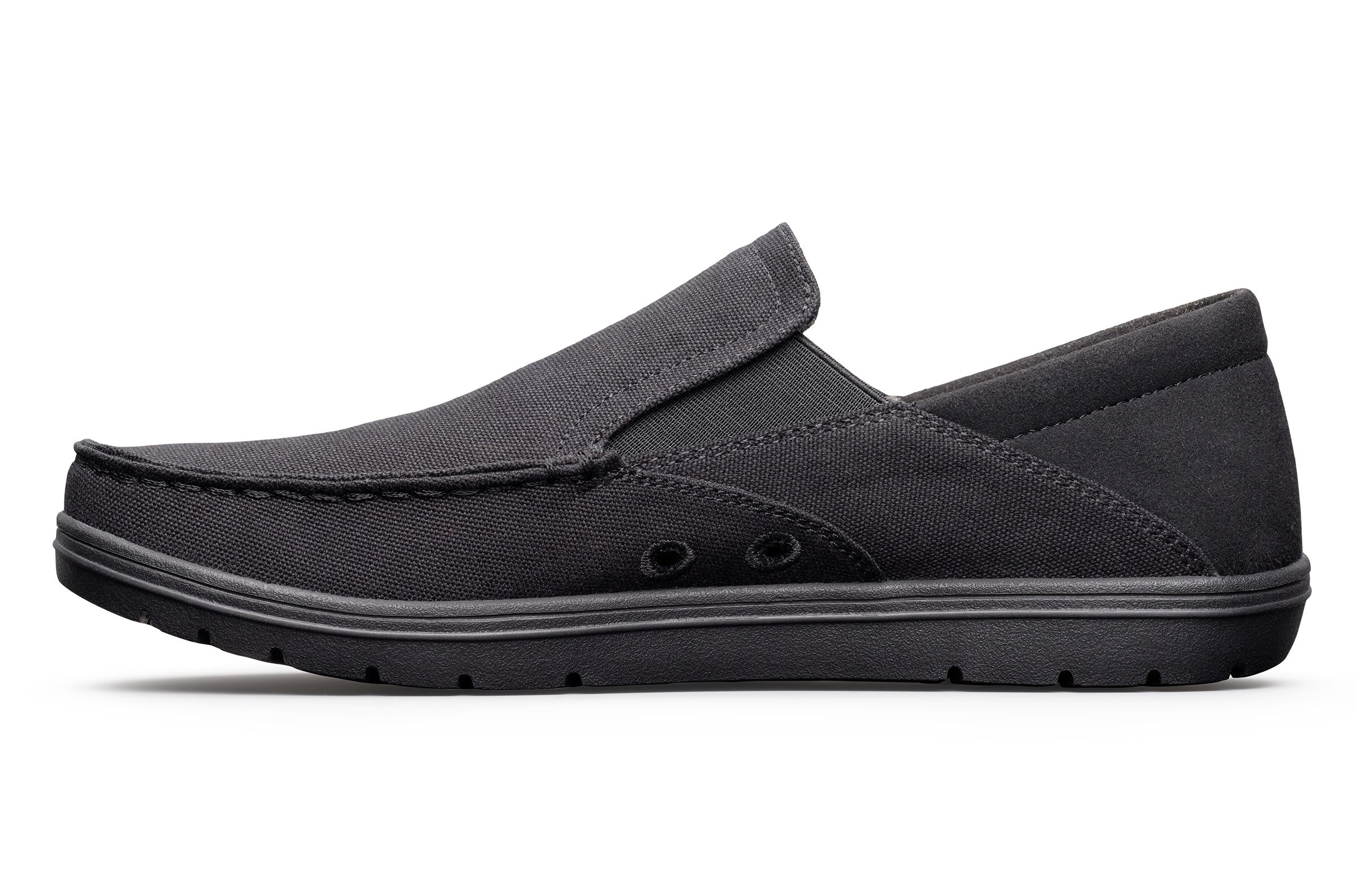 Black canvas slip-on casual shoe with low profile sole and subtle stitching details.
