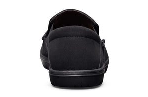 Black casual slip-on shoe with low profile sole and fabric upper, viewed from back.