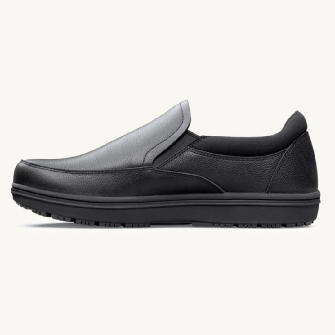 Black slip-on casual shoe with rounded toe and textured sole, padded collar for comfort.