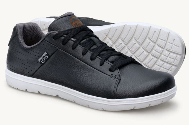 Black low-top leather sneakers with white rubber soles and black laces, casual style.