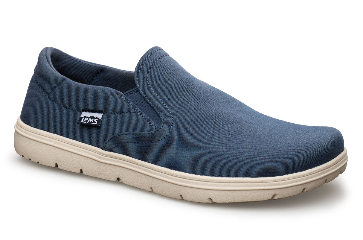 Navy blue slip-on canvas shoe with beige rubber sole and Lems logo tag on side.