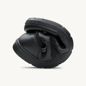 Flexible black leather casual shoe folded to show softness and outsole grip.