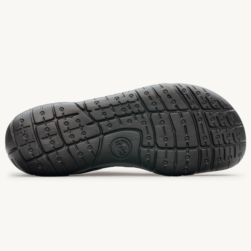Black rubber sole with flexible grooves and circular traction patterns on the Lems Primal 3 shoe.
