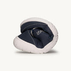 Navy blue Lems Primal 3 sneaker folded to show flexible white sole and soft upper material.