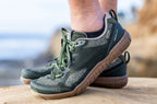 Green Lems Primal Eco athletic shoes with brown soles and knitted upper on feet outdoors.