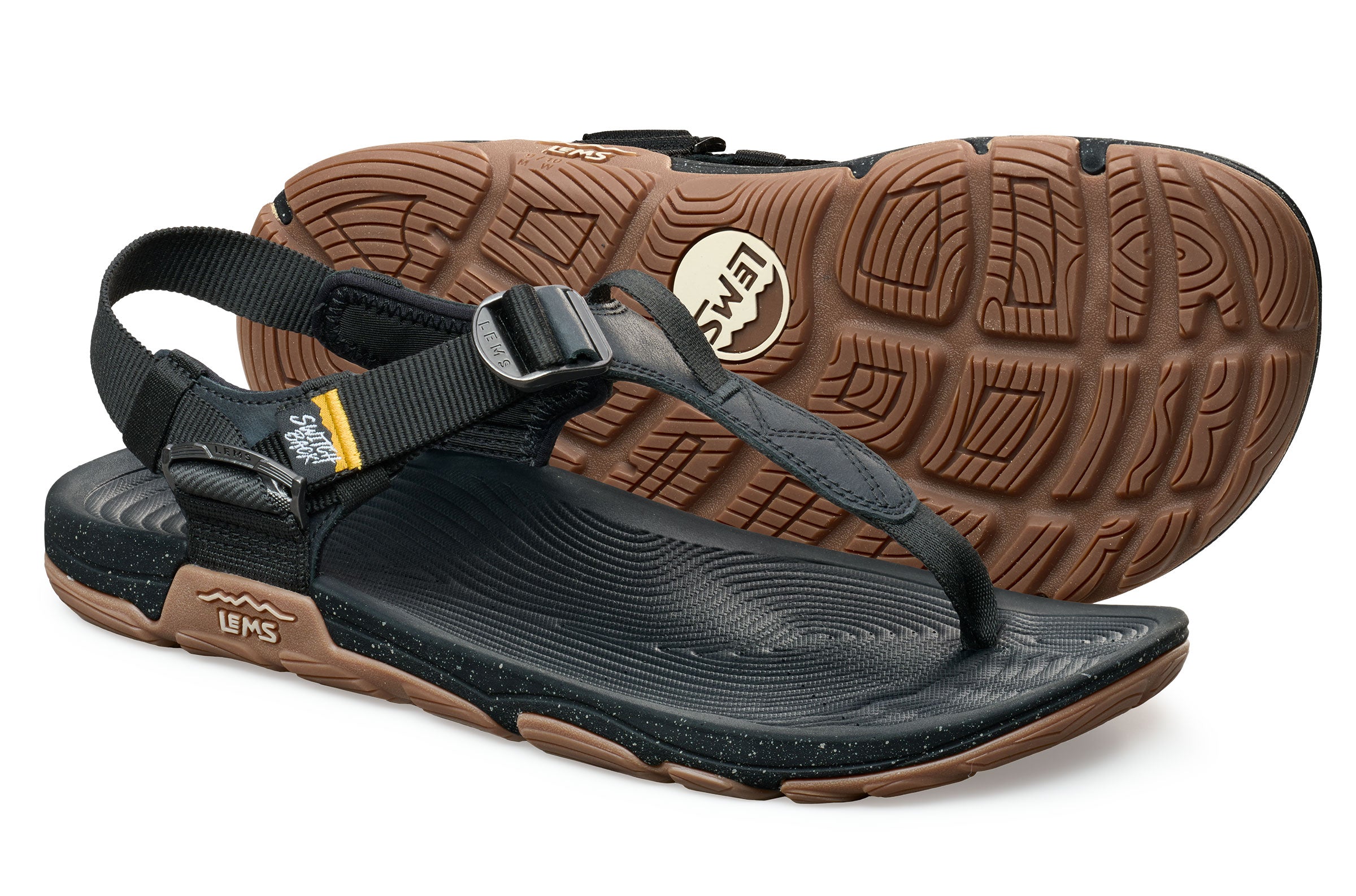 Black leather toe-loop sandals with adjustable straps and textured brown rubber soles.