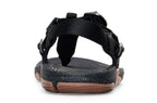 Black adjustable strap sandals with speckled footbed and brown textured sole.