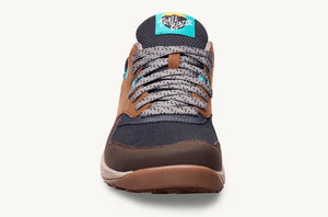 Brown and navy casual sneaker with patterned gray laces and logo patch on tongue.