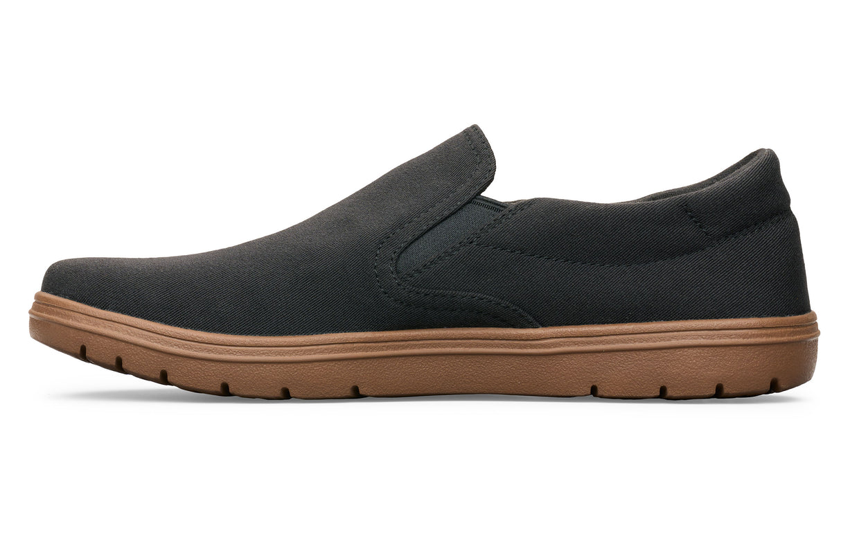 Black slip-on casual shoe with minimalist design and brown rubber sole.