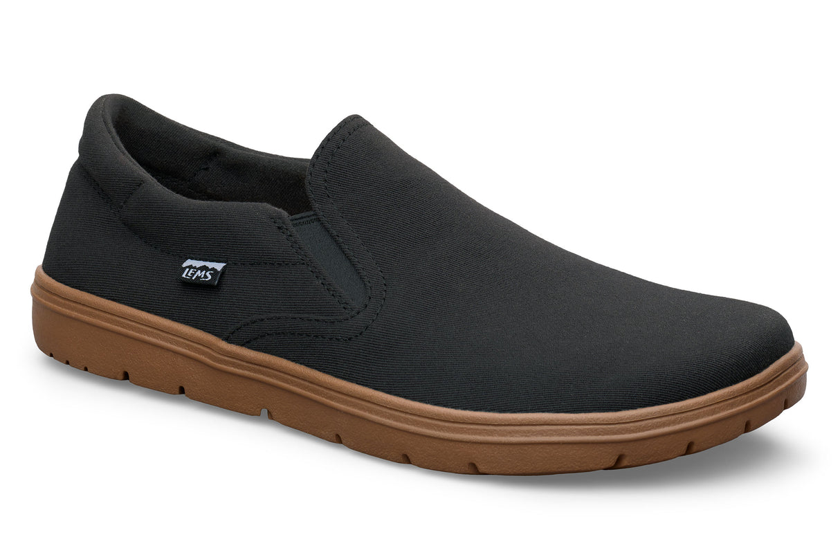 Black slip-on casual shoe with elastic side panels and brown rubber sole.