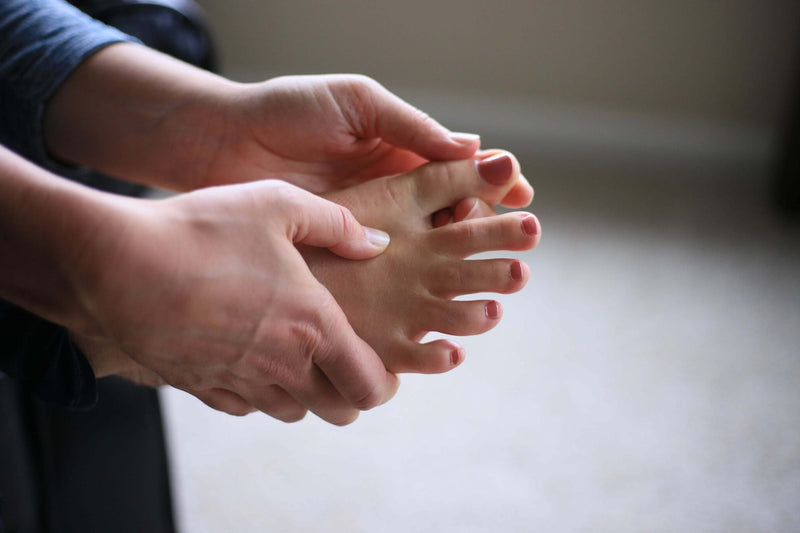 Woman massaging big toe on right foot