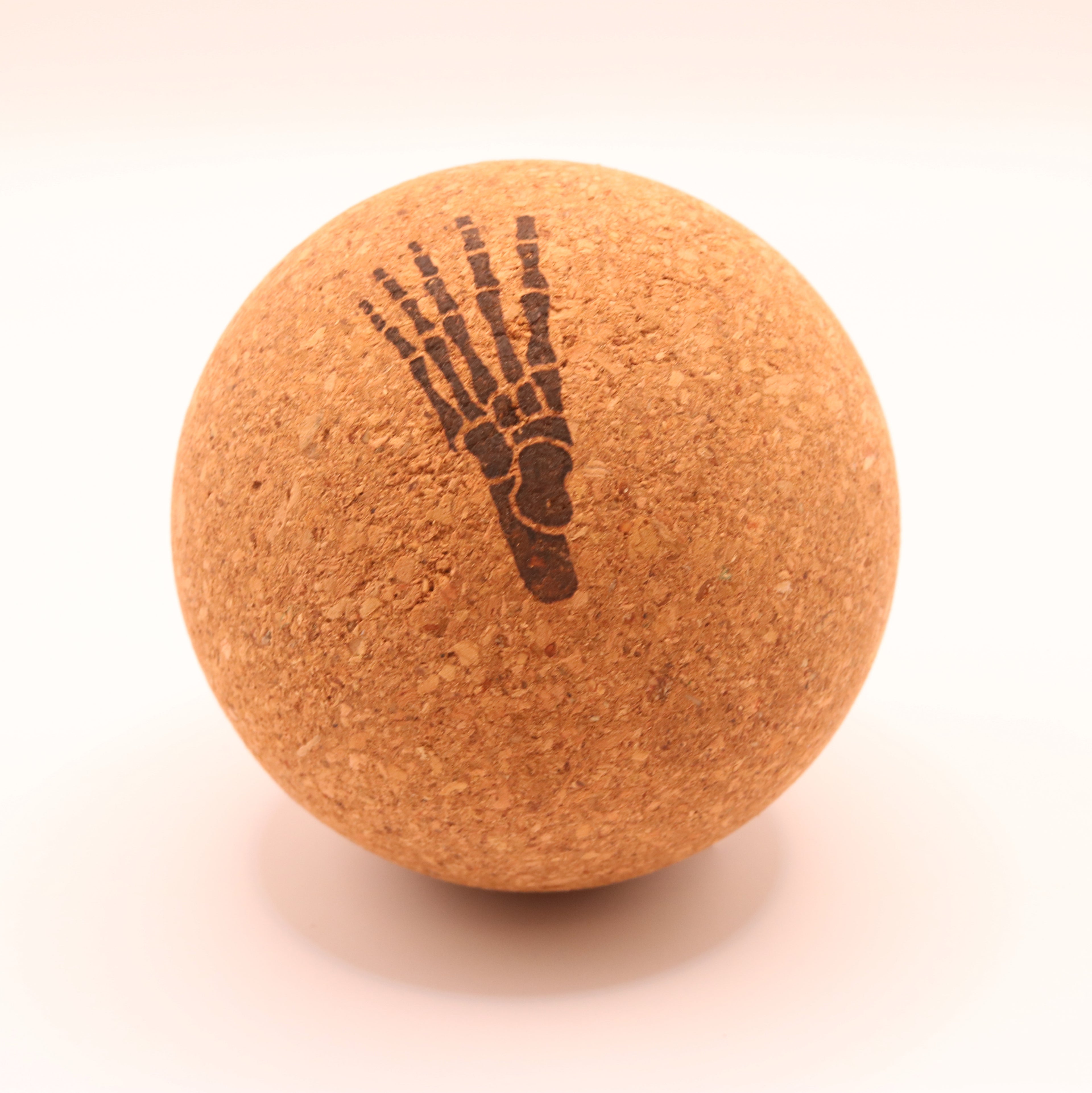 A round cork massage ball with a dark brown printed skeletal foot design, shown on a clean white background.