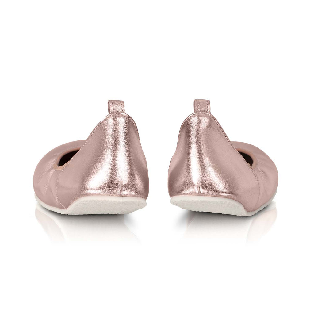 Rose gold wide barefoot ballerina flats with a smooth finish and a small heel tab, view from the back.