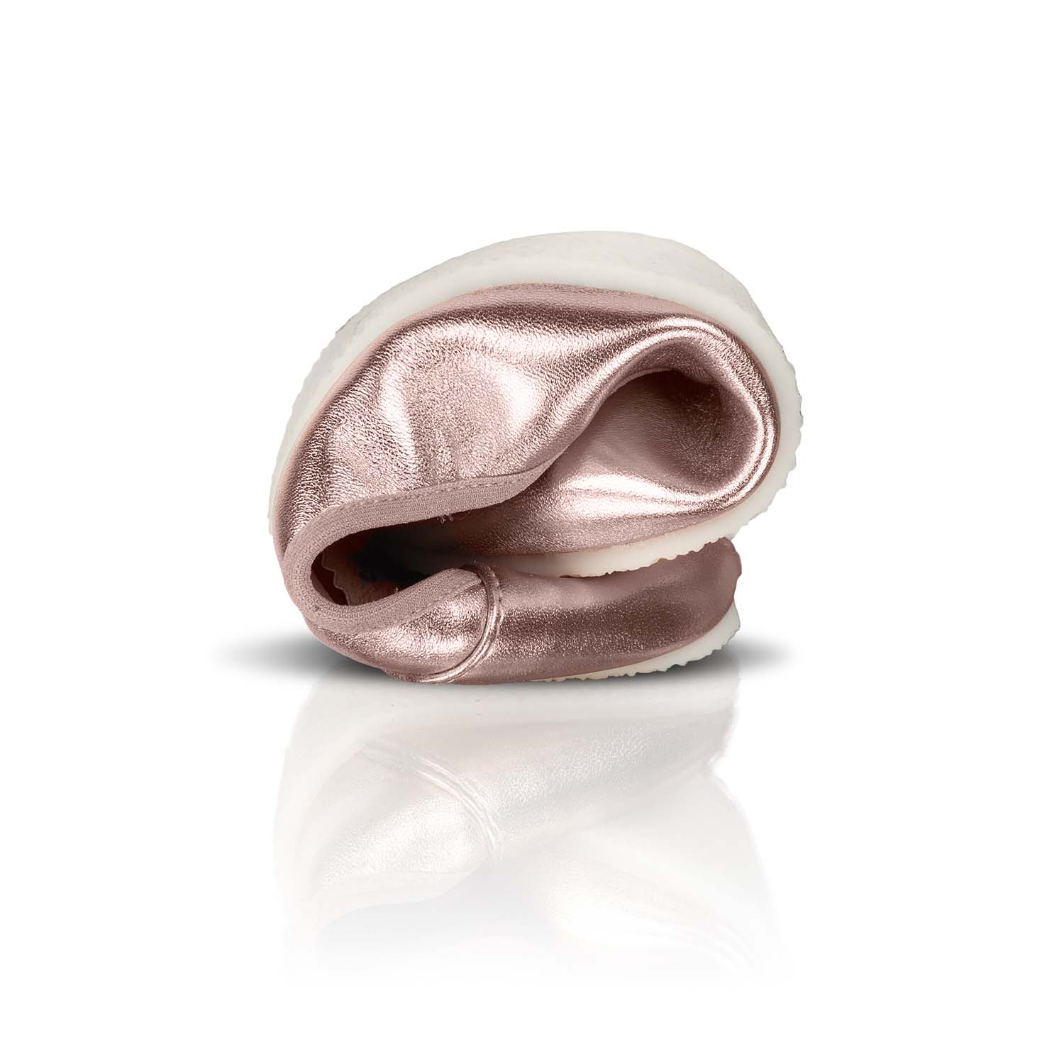 Rose gold metallic barefoot ballerina shoe folded to show flexibility with white sole.