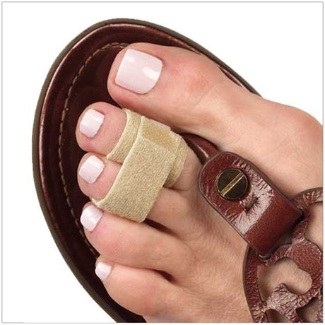 Narrow beige fabric toe loops on big toe securing foot in brown leather sandal.