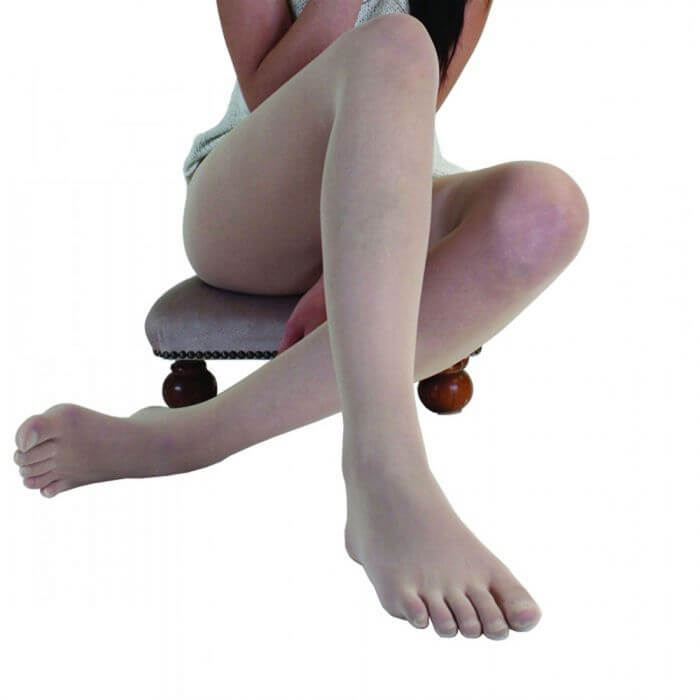 Beige sheer nylon toe tights worn on crossed legs seated on a chair with wooden legs.