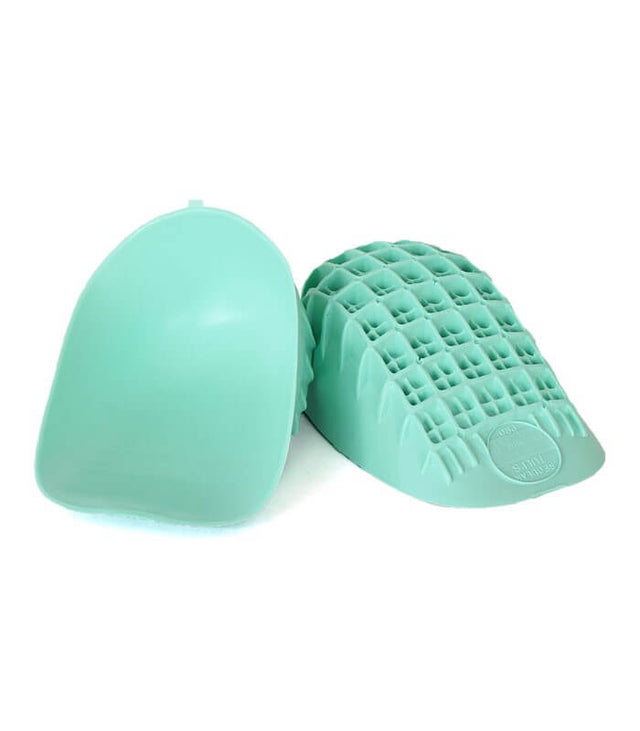 Pair of light green Tuli's heel cups with textured grid pattern on the sole and smooth top surface.