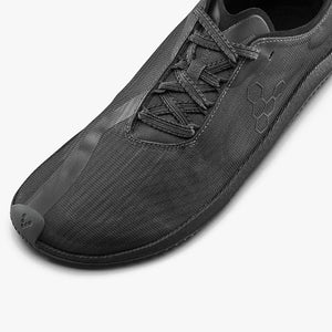 Dark shadow athletic shoe with textured upper, slim laces, and subtle embossed logo on side.