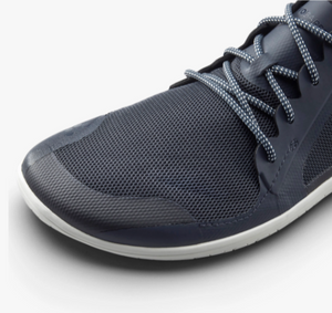 Navy athletic shoe with breathable textile upper, reflective laces, and white sole.