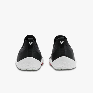 Pair of black Vivobarefoot Primus Trail Knit FG shoes shown from the back with white textured soles and red accents.