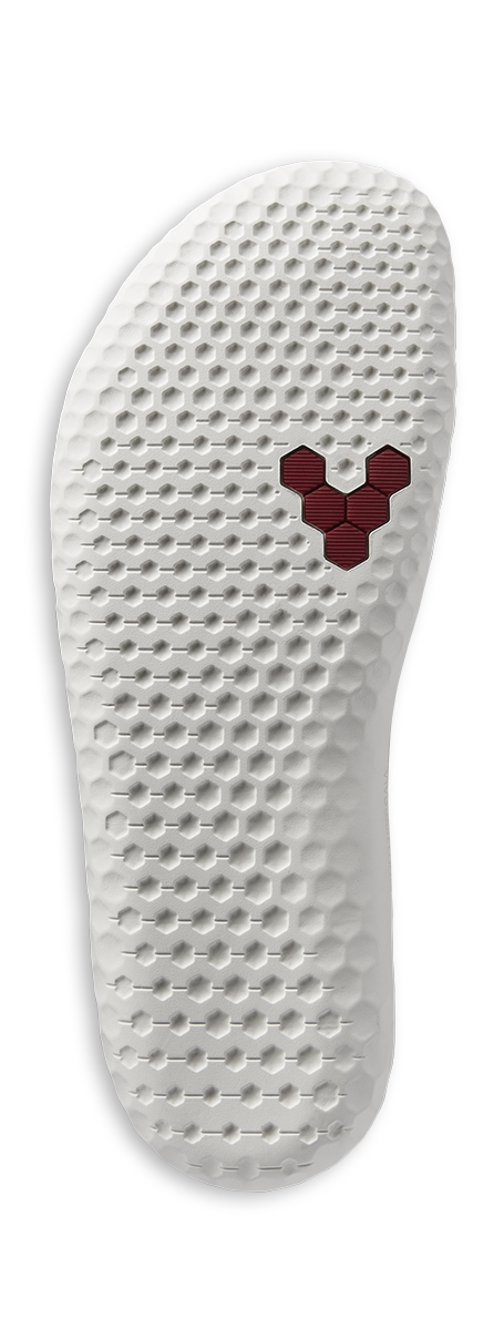 White textured shoe sole with a red hexagonal logo near the ball of the foot.