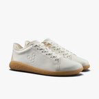 White leather low-top sneakers with gum rubber soles and minimalist design.