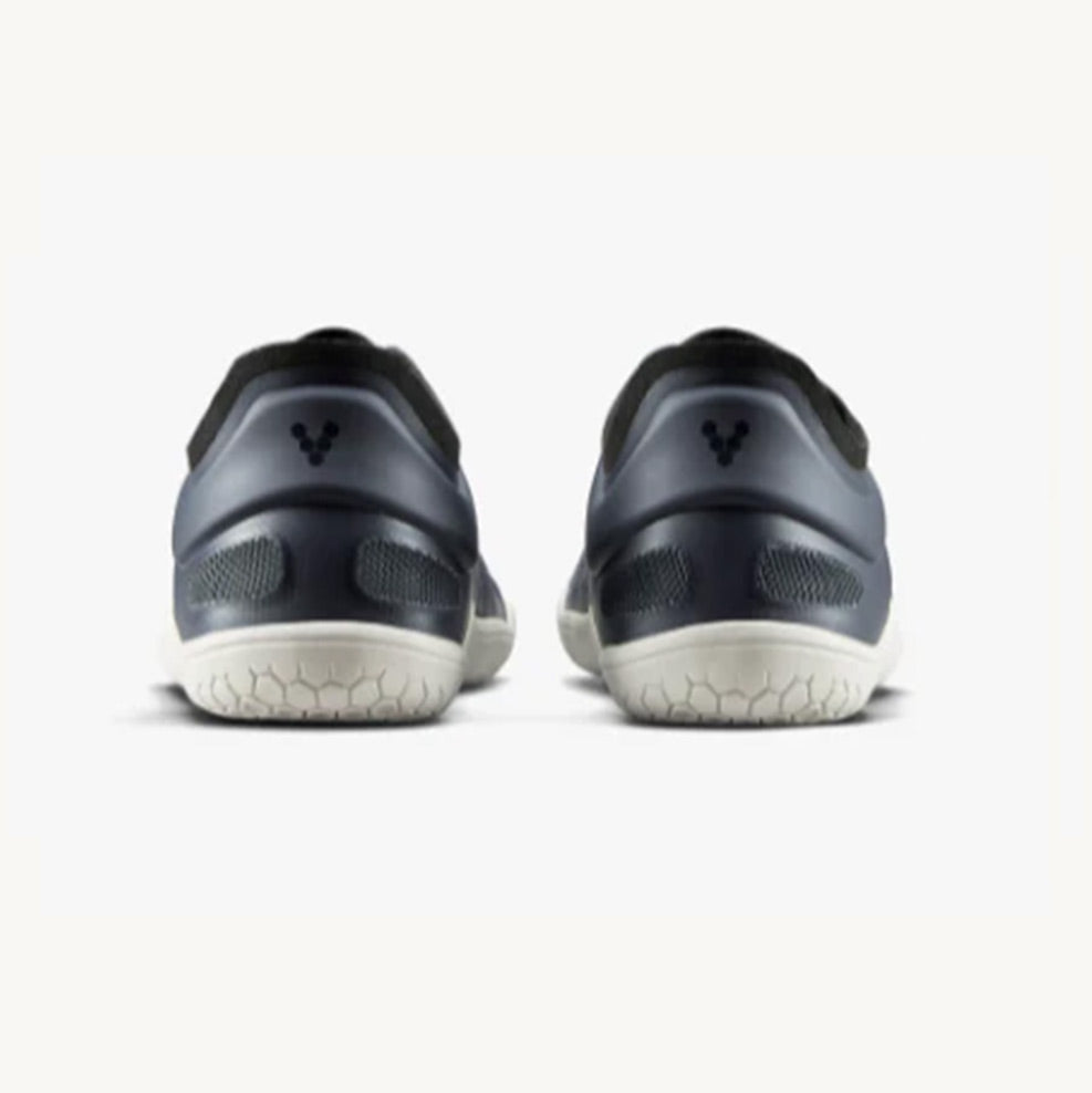 Pair of navy athletic sneakers with textured white soles, viewed from the back.