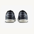 Pair of navy athletic sneakers with textured white soles, viewed from the back.