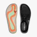 Black slip-on athletic shoe with laces, minimalist design, and orange-green hex pattern insole labeled Recycle.